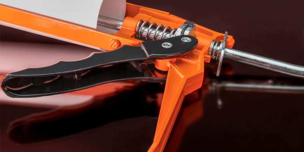 orange sealant gun closeup