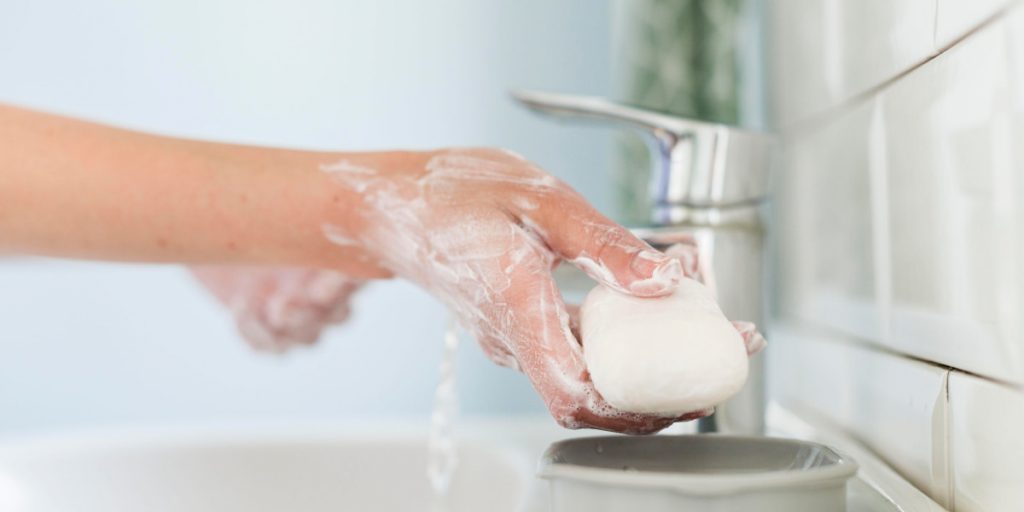 washing hands with soap in bathroom