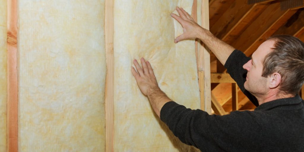 man adding wall insulation